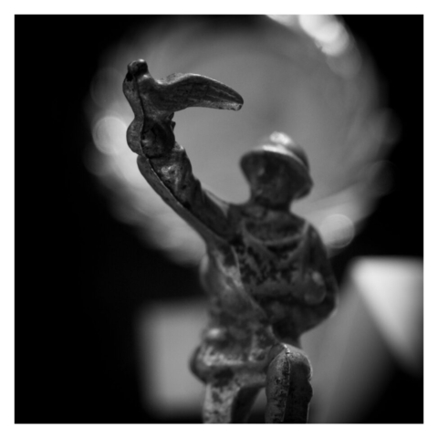 A lead model of a 'toy soldier' holding carrier pigeon