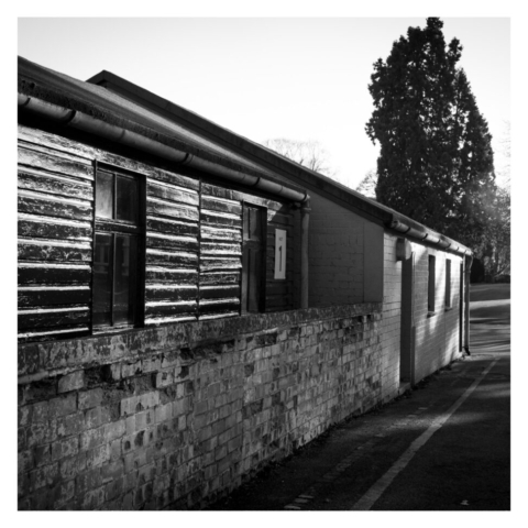 A wooden and brick hut in the late afternoon sunshine