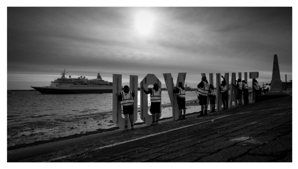 The letters Thank You are help up os the quayside as the ferry carrying D-Day veterans head for France