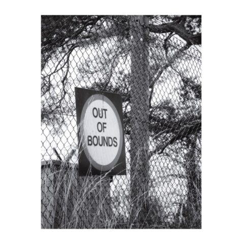 'OUT OF BOUNDS' sign on a high chain link security fence