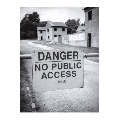 'DANGER NO PUBLIC ACCESS' sign in front of house-like' buildings constructed in the 1970s to aid urban warfare training.